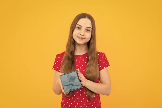 Portrait of teenager child girl 12, 13, 14, years old holding Christmas gift box. Teen giving birthday gift