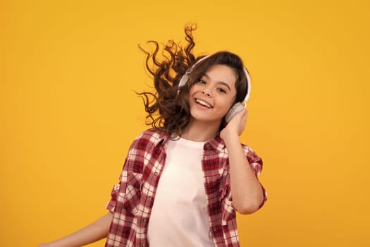 Funny kid girl 12, 13, 14 years old listen music with headphones. Teenage girl with headphones listening songs on headset earphone. Happy teenager, positive and smiling emotions of teen girl