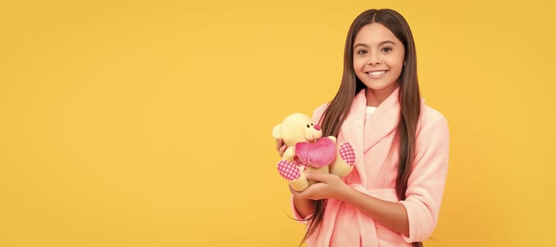 happy teen girl in home terry bathrobe with toy, happiness. Banner of child girl with toy, studio portrait, header with copy space