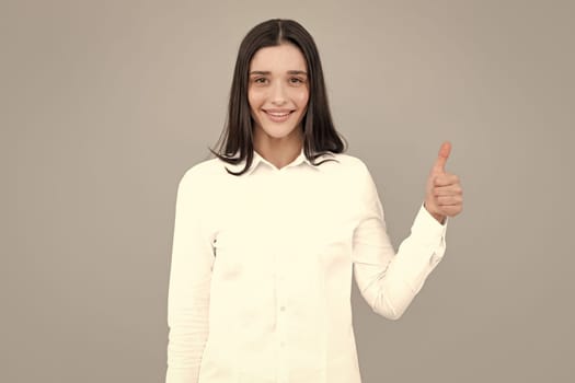 Woman point at copy space, showing copyspace pointing. Promo, girl showing advertisement content gesture, pointing with hand recommend product. Isolated gray background
