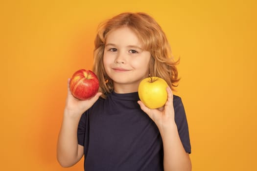 Apples. Kid with apple in studio. Studio portrait of cute child hold apple isolated on yellow background