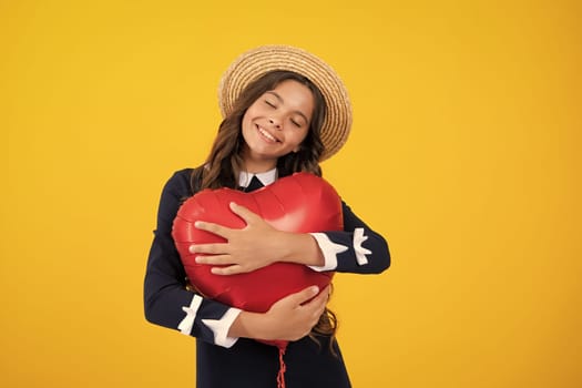 Teenage girl hold shape heart balloon, heart-shape sign. Child holding a red heart love holiday valentine symbol