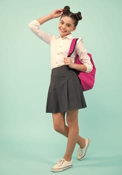 Back to school. Teenager schoolgirl in school uniform with bag. School children on isolated studio background. Happy teenager, positive and smiling emotions of teen girl