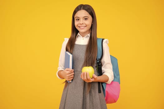 Back to school. Teenager schoolgirl hold book and copybook ready to learn. School children on isolated yellow studio background