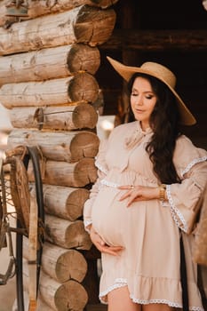 pregnant woman in a dress and hat in the countryside.