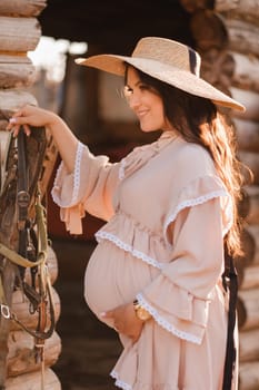 pregnant woman in a dress and hat in the countryside.