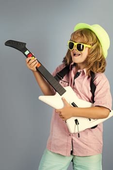 Musik education. Happy smiling child learning to play the guitar. Rock and roll guitar