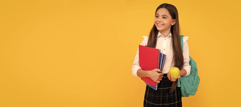 happy child with backpack and workbooks hold apple lunch in school uniform. Banner of school girl student. Schoolgirl pupil portrait with copy space