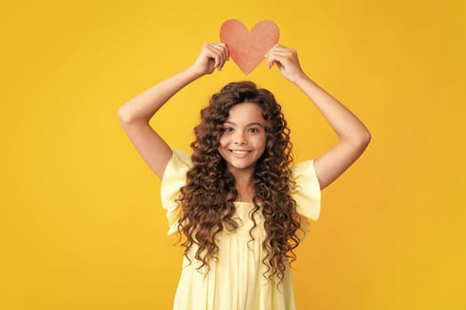 Happy teenager portrait. Lovely child teen girl with shape heart love holiday and valentine symbol. Valentine or birthday day. Gift heart present. Smiling girl