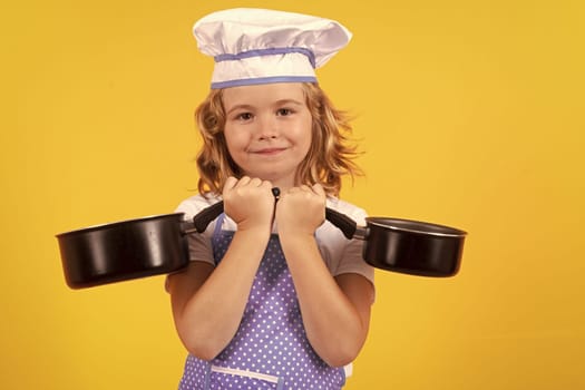 Kid chef cook with cooking pot stockpot. Child chef cook, studio portrait. Kids cooking. Teen boy with apron and chef hat