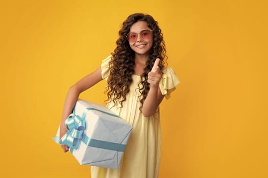 Child with gift present box on isolated background. Presents for birthday, Valentines day, New Year or Christmas. Happy teenager, positive and smiling emotions of teen girl