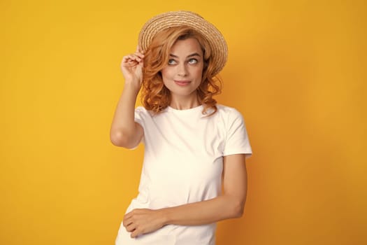 Excited amazed woman in straw hat isolated on yellow studio background