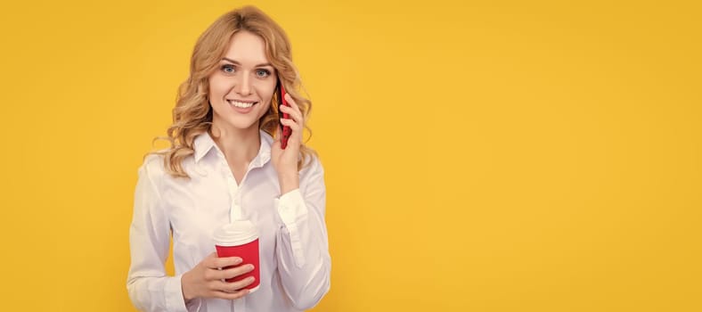 happy blonde woman with coffee cup talking on phone on yellow background. Woman isolated face portrait, banner with mock up copy space