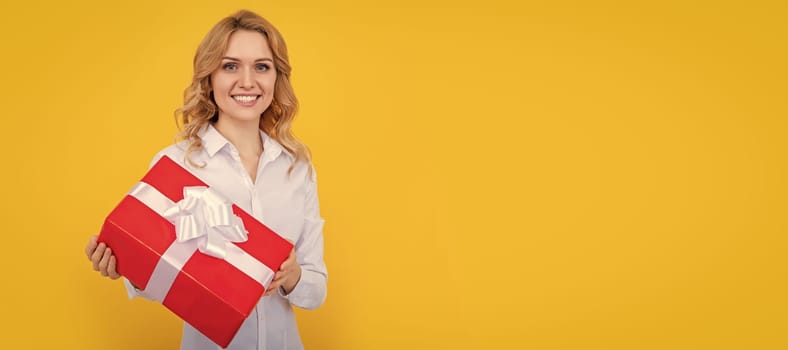 glad woman with big present box on yellow background. Woman isolated face portrait, banner with mock up copy space