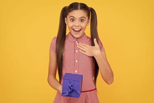 surprised teen girl hold present box on yellow background, surprise.