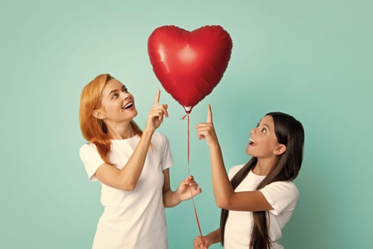 Mothers day. Smiling mother and daughter isolated on blue background. Birthday holiday party, people emotions concept. Celebrating holding heard air balloons