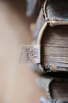 Back to school tag and old books on a wooden shelf.