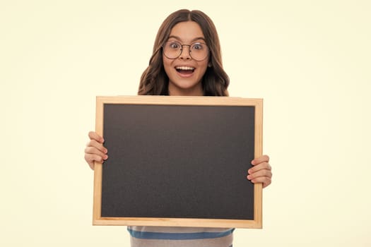 Teenager child holding blank chalkboard for message Isolated on a white studio background. Empty text blackboard, copy space mock up. Happy girl face, positive and smiling emotions