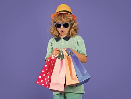 Fashion kid with shopping bag in studio. Little shopper child