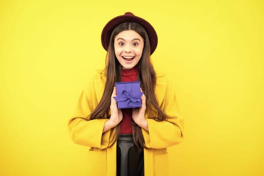 Happy teenager autumn portrait. Happy girl face, positive and smiling emotions. Teenager kid with present box. Teen girl giving birthday gift. Present, greeting and gifting concept. Smiling girl