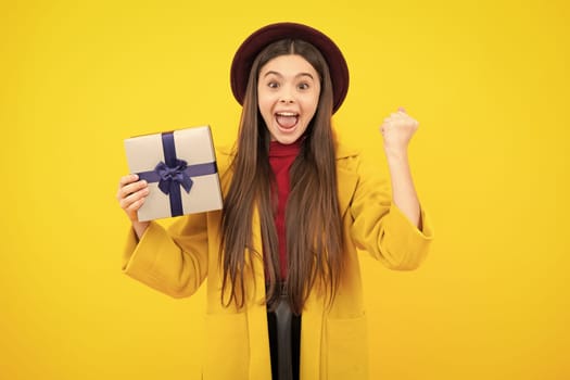 Emotional teenager child hold gift on birthday. Funny kid girl holding gift boxes celebrating happy New Year or Christmas. Excited teenager, glad amazed and overjoyed emotions
