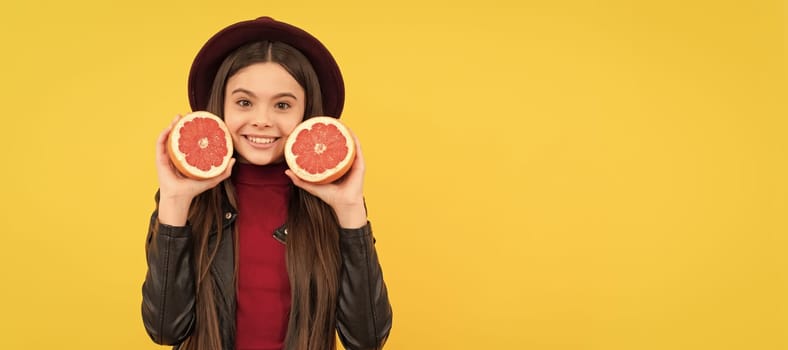 happy teen girl in hat and leather jacket hold cut grapefruit. Child girl portrait with grapefruit orange, horizontal poster. Banner header with copy space