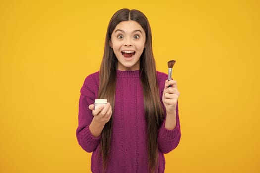 Excited face. Child teen girl making beauty make up, hold powder and brush. Beautiful teenager applying makeup with powder. Amazed expression, cheerful and glad