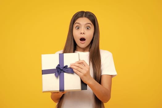 Amazed surprised emotions of young teenager girl. Teenager kid with present box. Teen girl giving birthday gift. Present, greeting and gifting concept