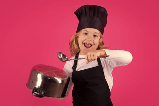 Fynny kid chef cook with cooking pot and ladle. Kid chef cook, studio portrait. Children cooking. Kid boy with apron and chef hat