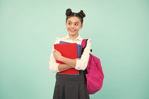 Back to school. Schoolgirl student hold book on blue isolated studio background. School and education concept. Teenager girl in school uniform. Happy teenager, positive and smiling schoolgirl