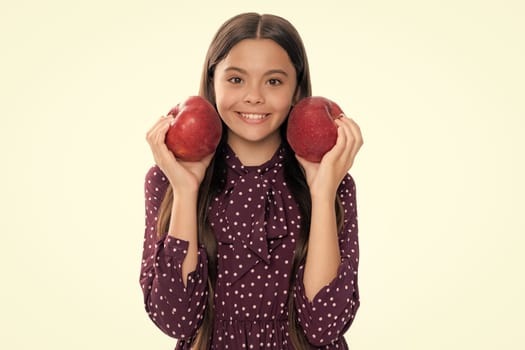 Child girl eating an apple over isolated white studio background. Tennager with fruit. Portrait of happy funny smiling teenage child girl