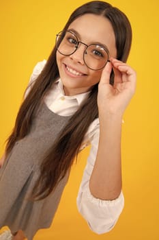 Portrait of teenager child in glasses. Kid at eye sight test. Girl holding eyeglasses and looking at camera. Vision, eyesight measurement for school children