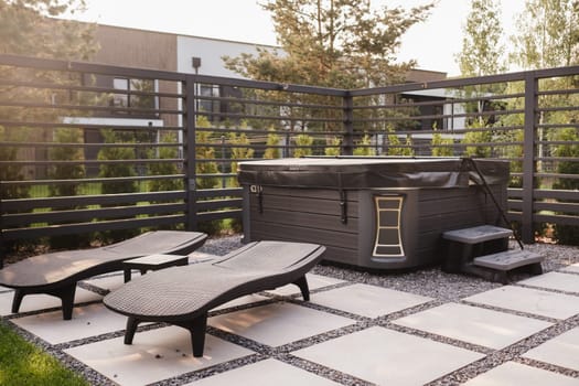 A hot tub and sun loungers in a country house. On the terrace there is a swimming pool with hydromassage.