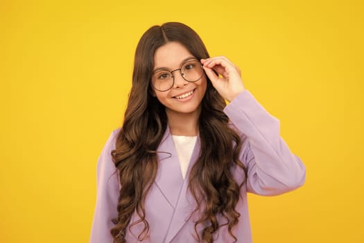 Teenager child wearing glasses on yellow studio background. Cute girl in eyeglasses