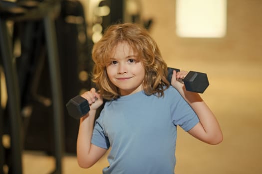Sport activities at leisure with children. Boy holding dumbbells
