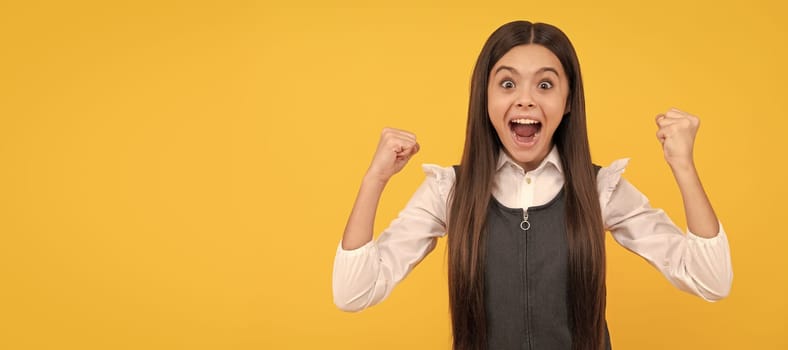 Happy teenage girl winner give winning gesture celebrating victory yellow background, won. Child face, horizontal poster, teenager girl isolated portrait, banner with copy space