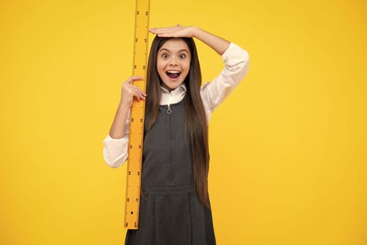 Kid height measure, growth measurement. Back to school. Teenager school girl on yellow background. Excited face, cheerful teenager school girl with school supplies