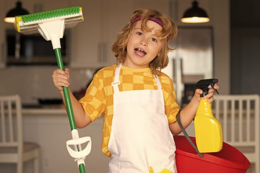 Portrait of child cleaning, concept growth, development, family relationships. Housekeeping and home cleaning concept. Child use duster and gloves for cleaning. Home kitchen background