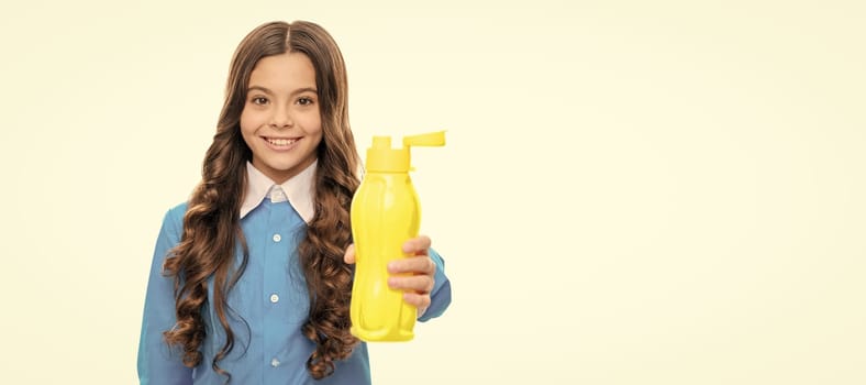 Happy girl give yellow plastic bottle. Hydration fluid. Get hydration from the diet. Horizontal poster of isolated child face, banner header, copy space