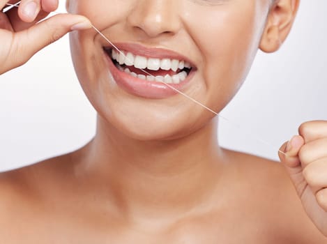 Mouth, face and woman floss teeth for dental health, care or gingivitis on studio background. Closeup of female model, oral thread and cleaning string for fresh breath, tooth hygiene or healthy habit.