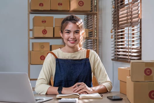 Portrait of Asian young woman SME working with a box at home the workplace.start-up small business owner, small business entrepreneur SME or freelance business online and delivery concept...