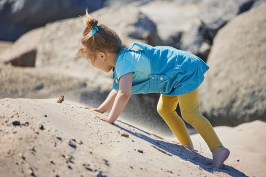 Charming child playing on the beach in Denmark.