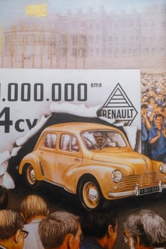19 April 2023 Paris, France. Photo of a poster celebrating production of one million Renault 4cv showing a yellow car breaking through a paper banner while crowds of people cheer. Factory workers applaud the production of the car built as France's answer to the German VW Beetle