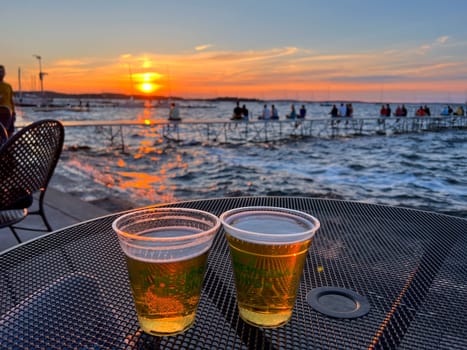 MADISON, WISCONSIN, JULY 16 2022: Drinking two beers during summer sunset at Madison Memorial Union. High quality photo