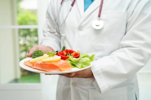 Asian Nutritionist holding healthy food for patient in hospital, nutrition and vitamin.