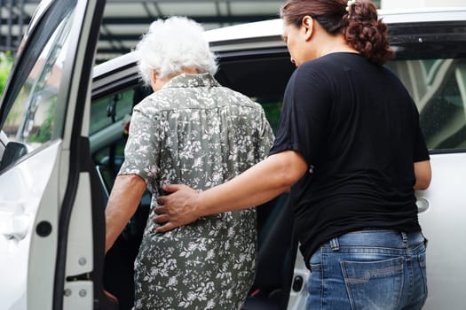 Caregiver help Asian elderly woman disability patient get in her car, medical concept.