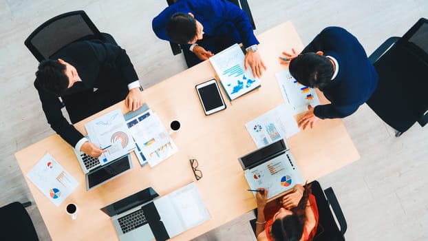 Business people group meeting shot from top view in office . Profession businesswomen, businessmen and office workers working in team conference with project planning document on meeting table . Jivy