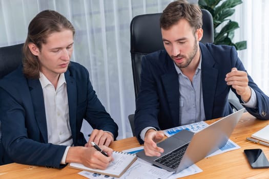 Busy analyst team in office analyzing financial data analysis for marketing strategy in workspace using BI dashboard with graph and chart on laptop screen to improve business performance. Entity