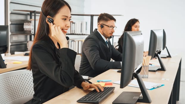 Business people wearing headset working in office to support remote customer or colleague. Call center, telemarketing, customer support agent provide service on telephone video conference call. Jivy