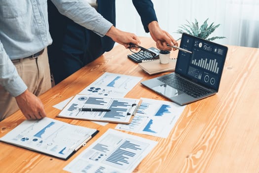 Busy analyst team in office analyzing financial data analysis for marketing strategy in workspace using BI dashboard with graph and chart on laptop screen to improve business performance. Entity